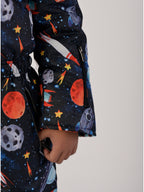 Luxury kids’ snowsuit with cosmic space print featuring rockets and planets, waterproof and breathable, Sorona® eco insulation, Oeko-Tex certified, handcrafted in Europe for warmth to −25°C.