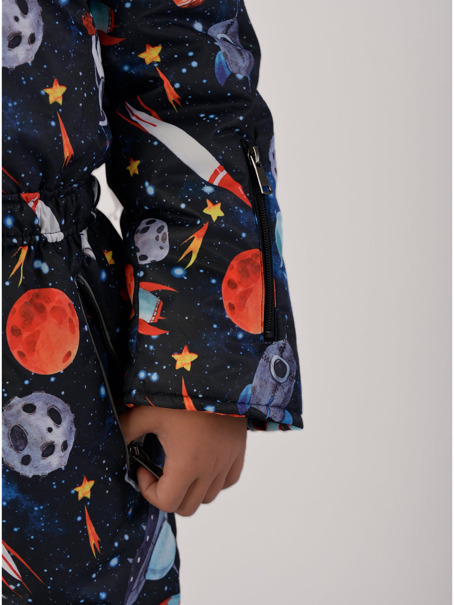 Luxury kids’ snowsuit with cosmic space print featuring rockets and planets, waterproof and breathable, Sorona® eco insulation, Oeko-Tex certified, handcrafted in Europe for warmth to −25°C.