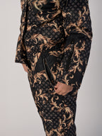 Luxury girls’ snowsuit with golden baroque print on black, handcrafted in Europe from waterproof polyester with Sorona® plant-based insulation. Warm and breathable winter overall for kids, certified Oeko-Tex Standard 100, perfect for skiing and cold weather up to −25°C.