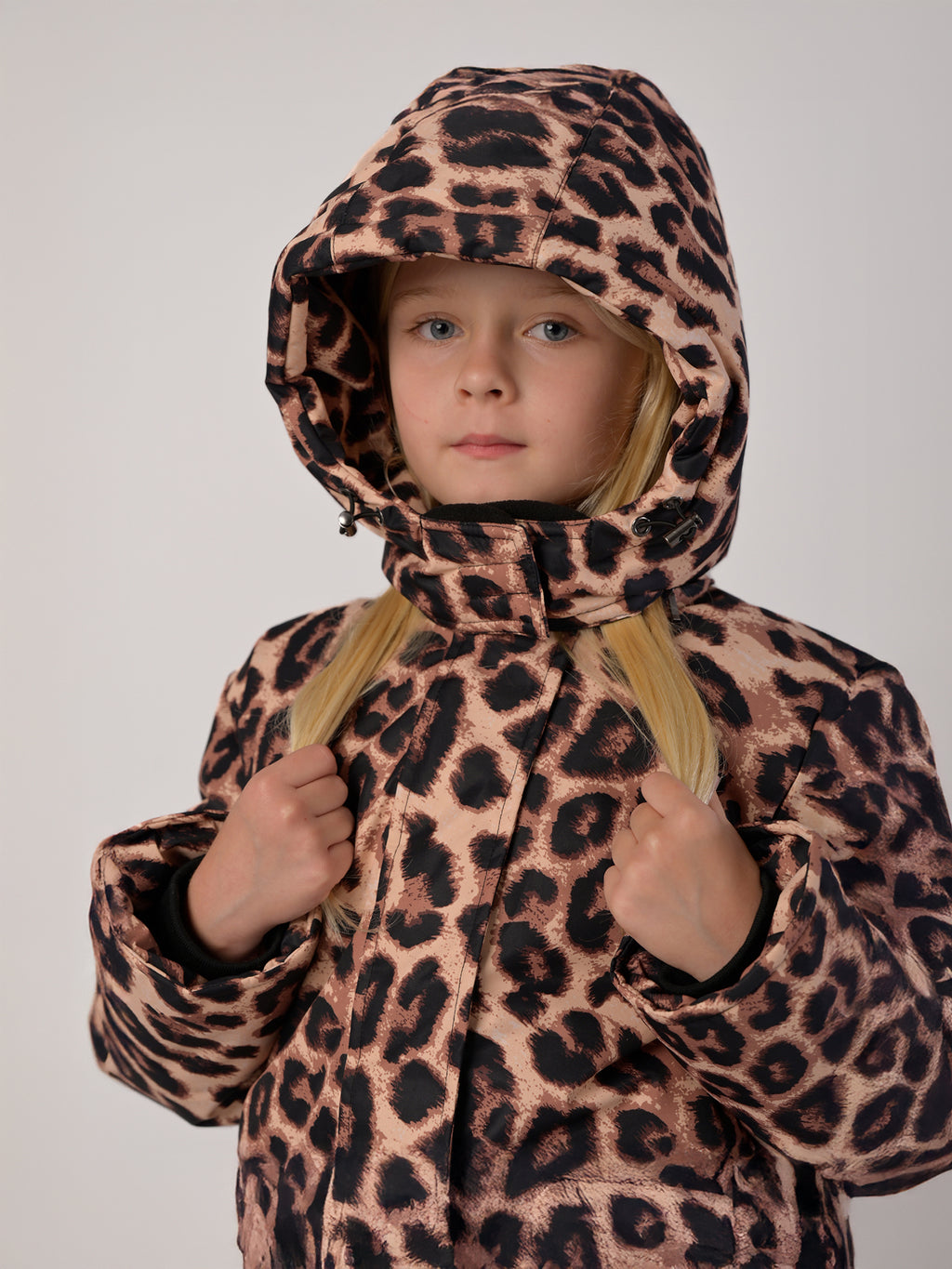 Luxury kids’ snowsuit with beige and brown leopard print, waterproof and breathable, Sorona® plant-based insulation, Oeko-Tex certified, handcrafted in Europe for warmth down to −25°C.
