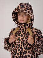 Luxury kids’ snowsuit with beige and brown leopard print, waterproof and breathable, Sorona® plant-based insulation, Oeko-Tex certified, handcrafted in Europe for warmth down to −25°C.