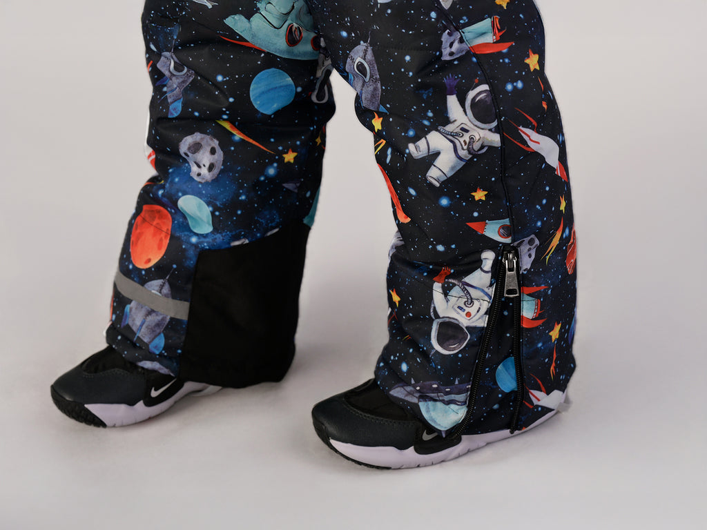 Luxury kids’ snowsuit with cosmic space print featuring rockets and planets, waterproof and breathable, Sorona® eco insulation, Oeko-Tex certified, handcrafted in Europe for warmth to −25°C.