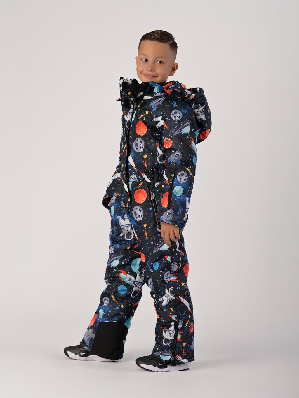 Luxury kids’ snowsuit with cosmic space print featuring rockets and planets, waterproof and breathable, Sorona® eco insulation, Oeko-Tex certified, handcrafted in Europe for warmth to −25°C.