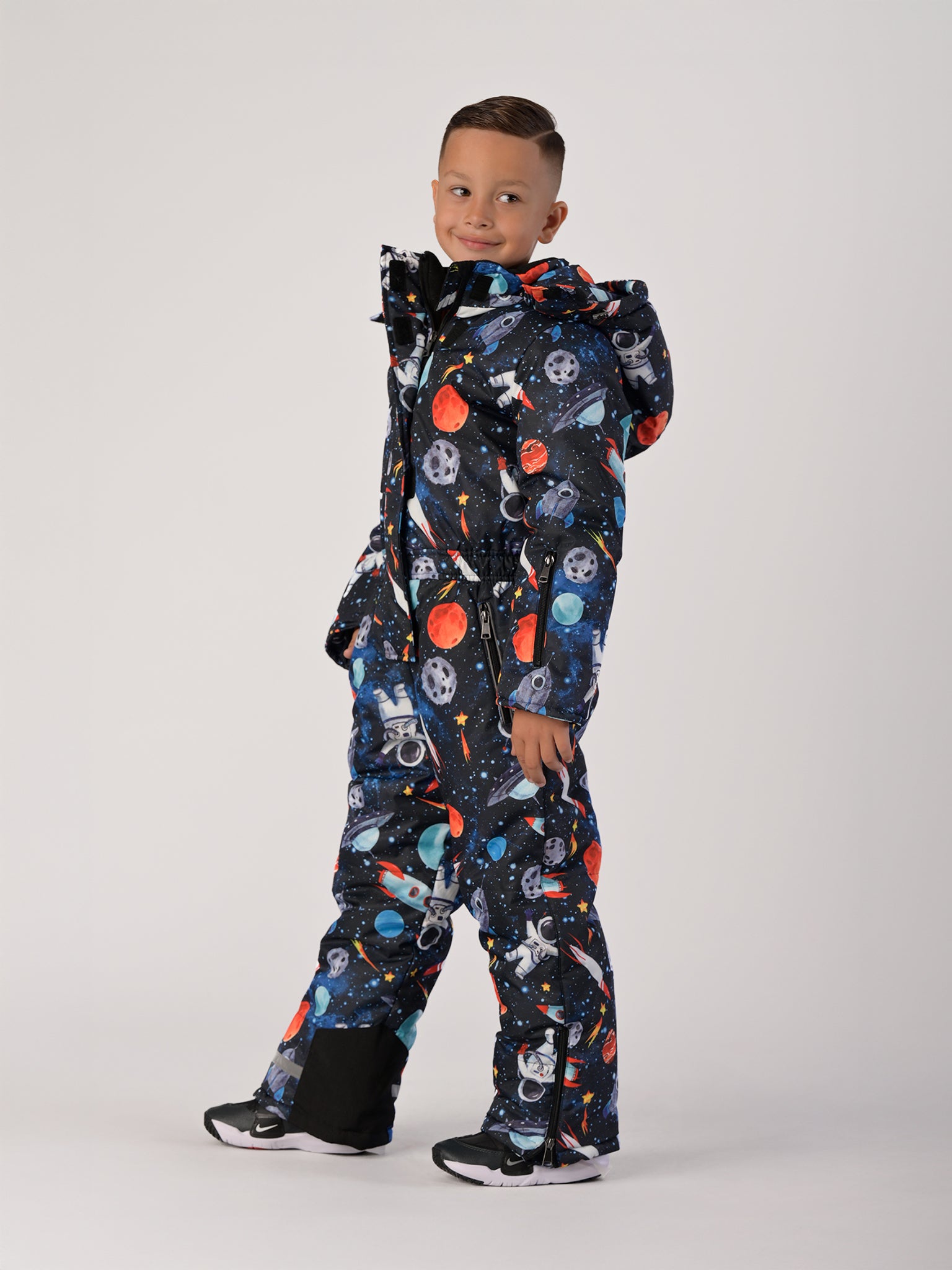Luxury kids’ snowsuit with cosmic space print featuring rockets and planets, waterproof and breathable, Sorona® eco insulation, Oeko-Tex certified, handcrafted in Europe for warmth to −25°C.